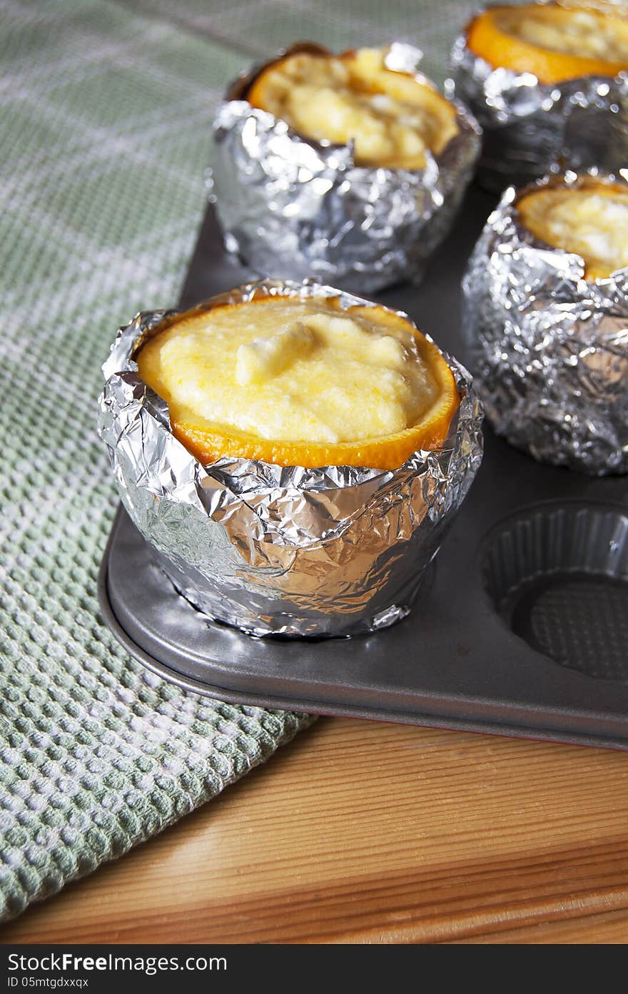 The process of making a dessert of orange and butter cream. Oranges filled with butter cream, prepared for baking. The process of making a dessert of orange and butter cream. Oranges filled with butter cream, prepared for baking.