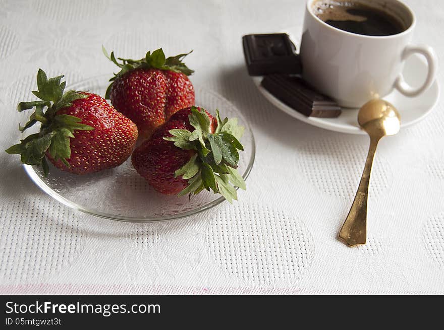 Strawberry, chocolate and a cup of coffee with golden spoon in the morning. Strawberry, chocolate and a cup of coffee with golden spoon in the morning