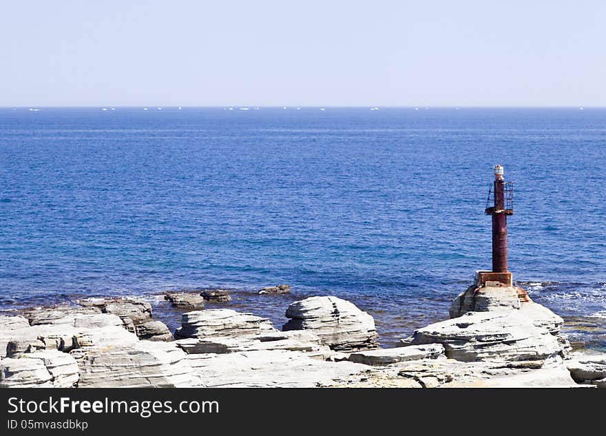 The sea and rocks under beams of a bright sun