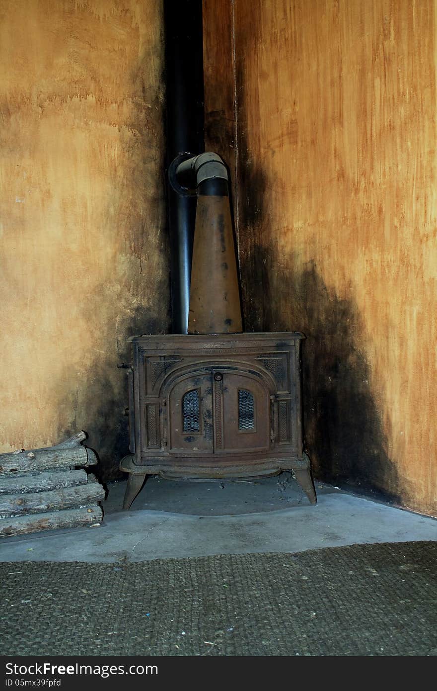 Old wood burning stove with soot marks on the surrounding walls