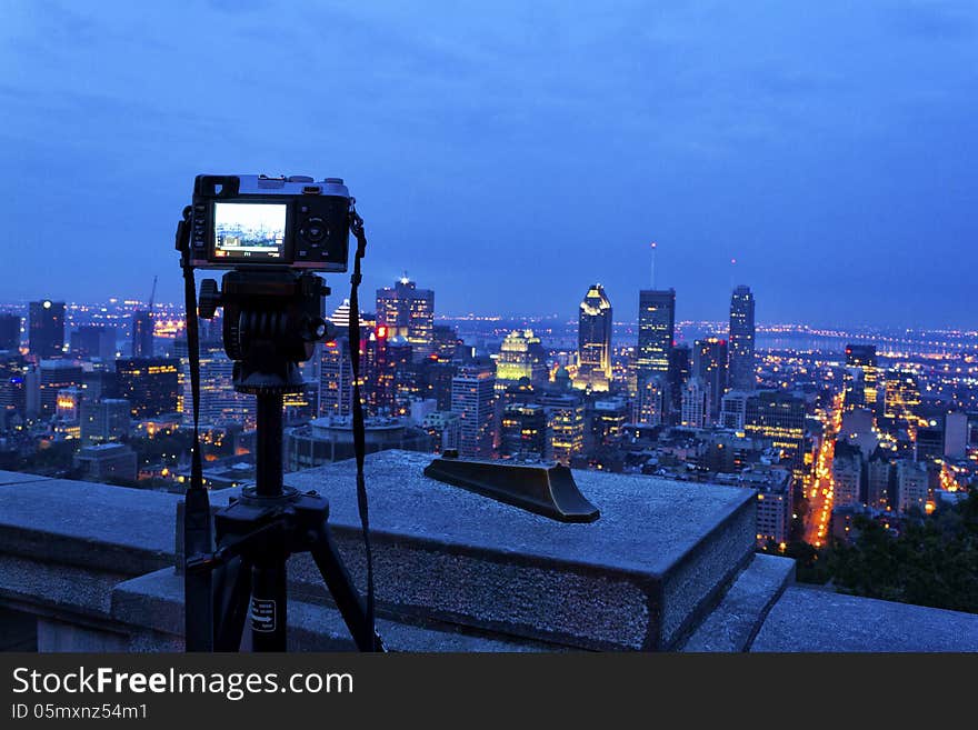 Camera on a tripod taking a picture of downtown Montreal from the vintage point Belvedere atop the Mont-Royal. Camera on a tripod taking a picture of downtown Montreal from the vintage point Belvedere atop the Mont-Royal