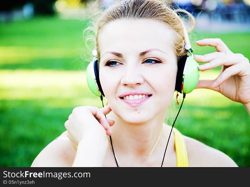 Young cheerful woman enjoing the music outdoors