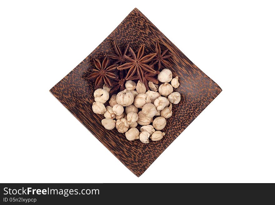 Star anise and camphor seeds on wood tray isolated on white background. Star anise and camphor seeds on wood tray isolated on white background