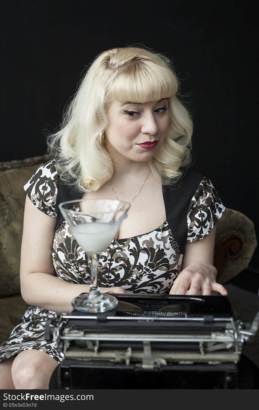 Portrait of a beautiful young woman with blond hair and brown eyes typing on a vintage typewriter. Portrait of a beautiful young woman with blond hair and brown eyes typing on a vintage typewriter.