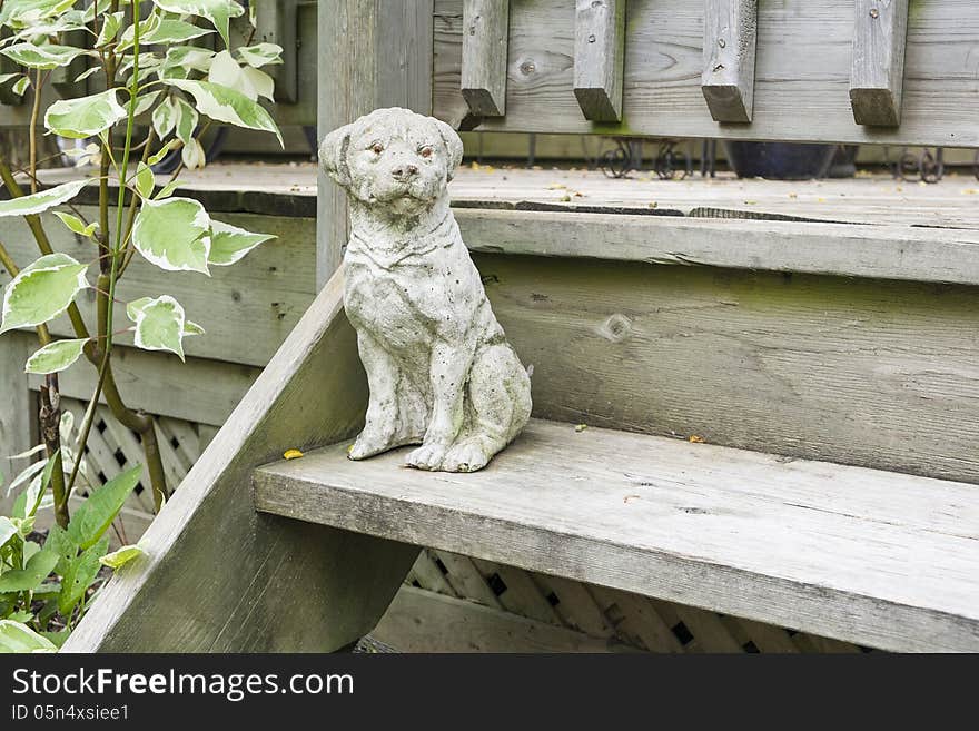 Dog statue on a step by the deck.