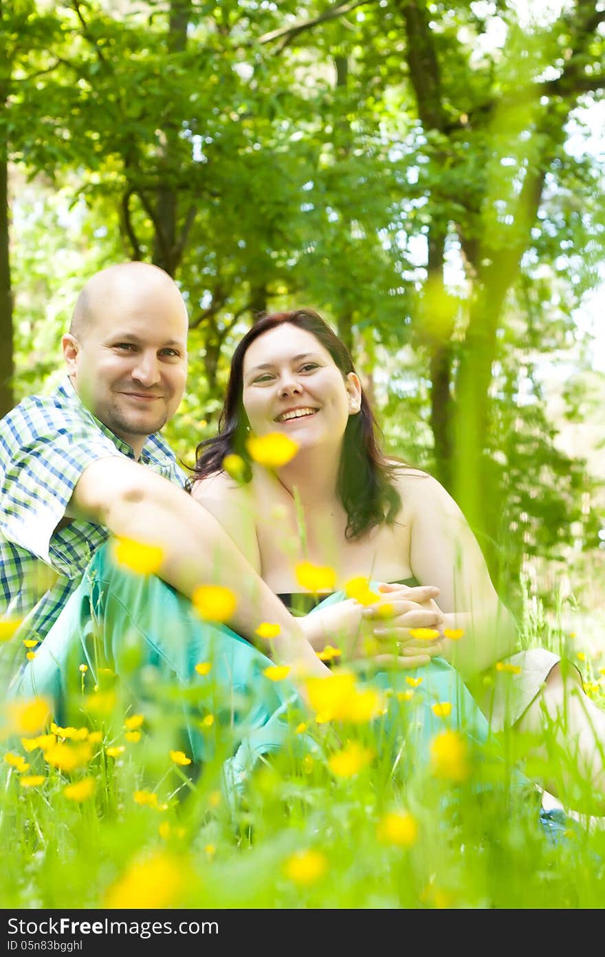 Happy young married couple between flowers