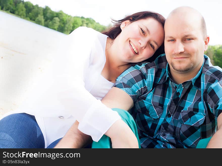 Happy young couple is having fun on a windy park beach. Happy young couple is having fun on a windy park beach