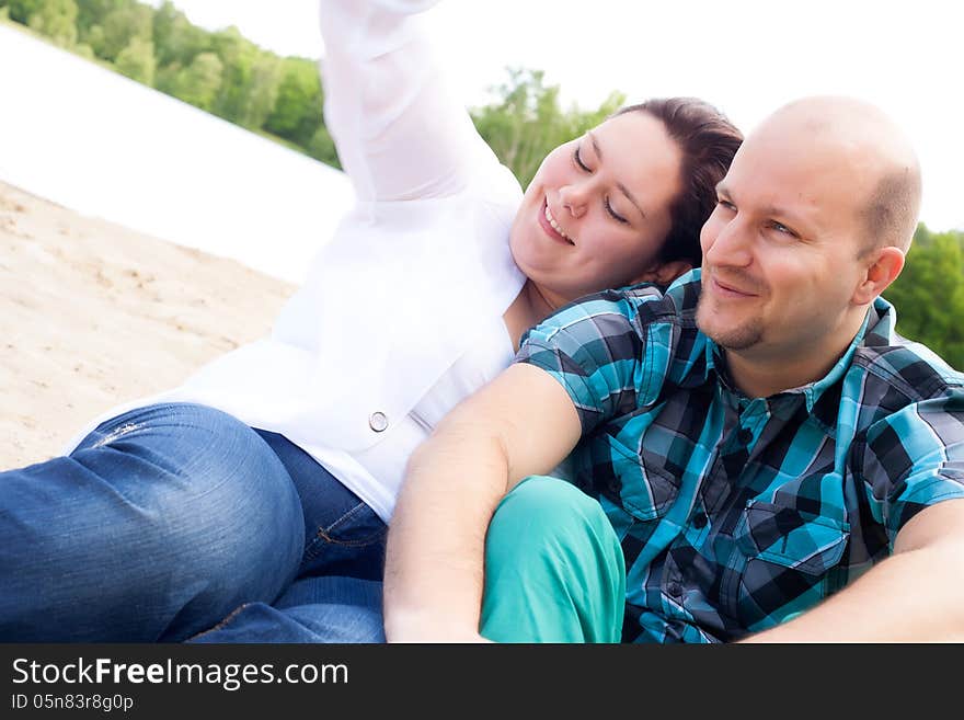 Happy young couple is having fun on a windy park beach. Happy young couple is having fun on a windy park beach