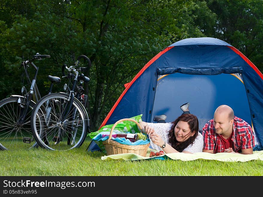 Happy young couple is relaxing on a camping. Happy young couple is relaxing on a camping