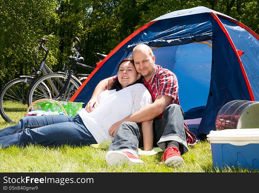 Happy young couple is relaxing on a camping. Happy young couple is relaxing on a camping