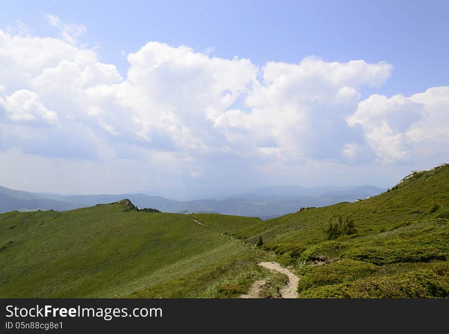 Summer mountain route, partly with storm clouds