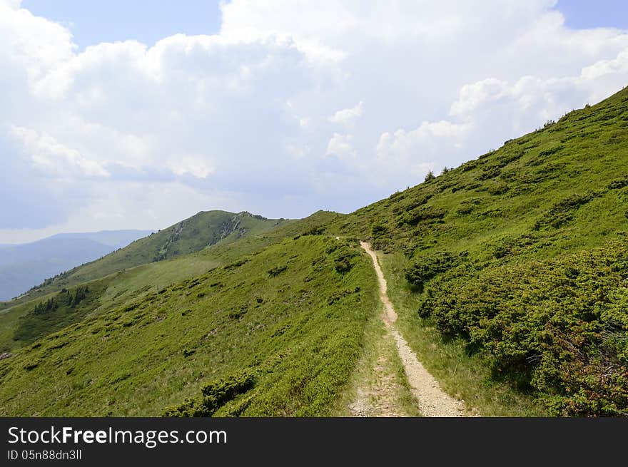 Summer mountain route, partly with storm clouds