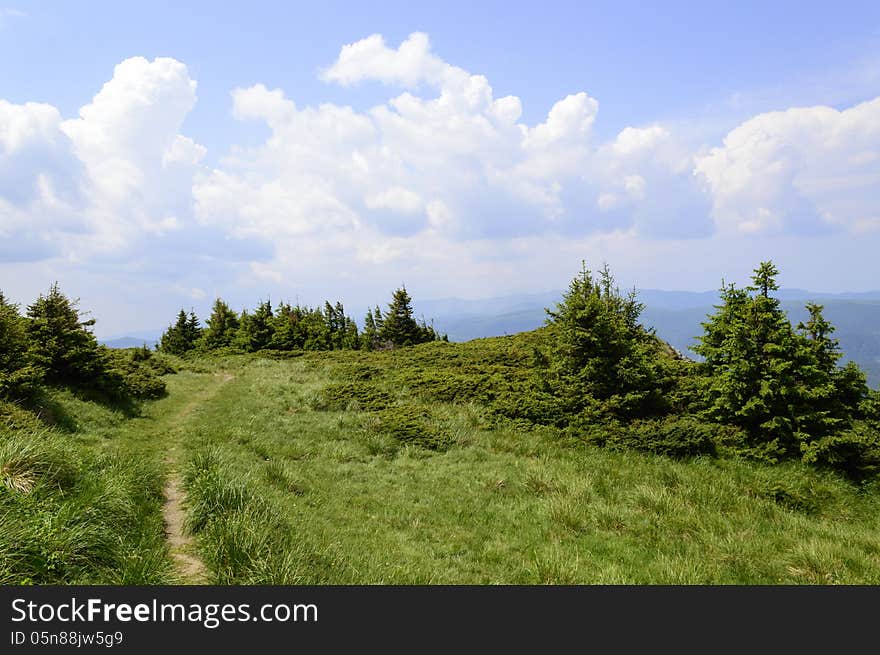 Summer mountain route, partly with storm clouds