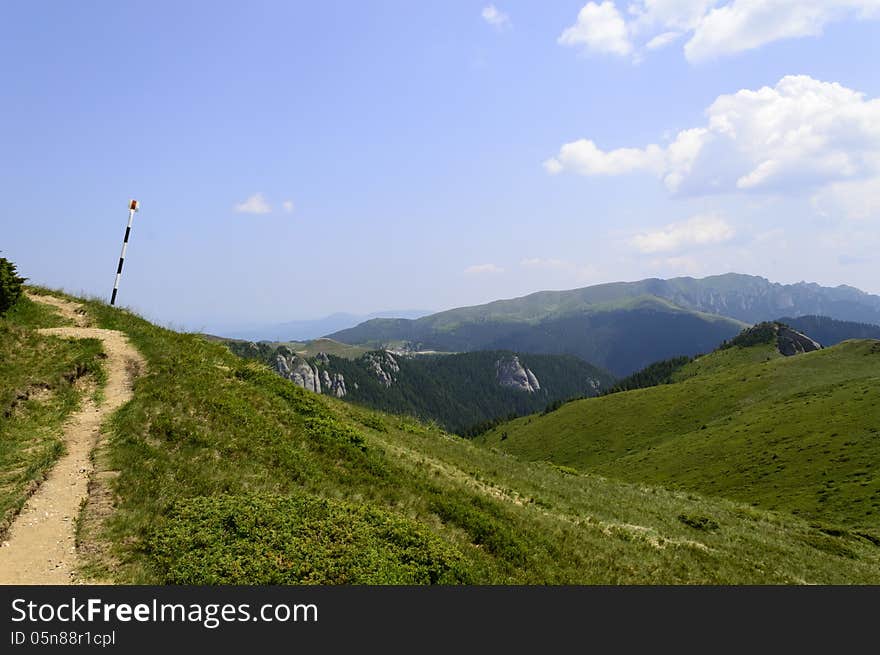 Summer mountain route, partly with storm clouds