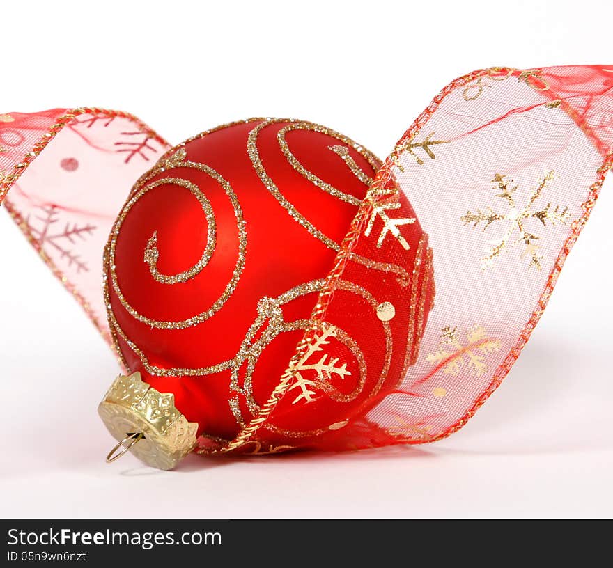 Red-golden bauble with the ribbon on the white background. Red-golden bauble with the ribbon on the white background