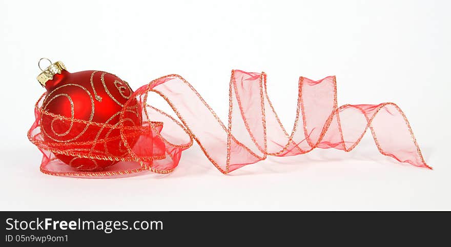 Red-golden bauble with the ribbon on the white background. Red-golden bauble with the ribbon on the white background