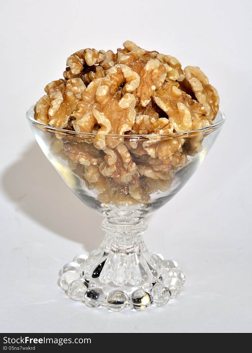 A small glass bowl of shelled walnuts.