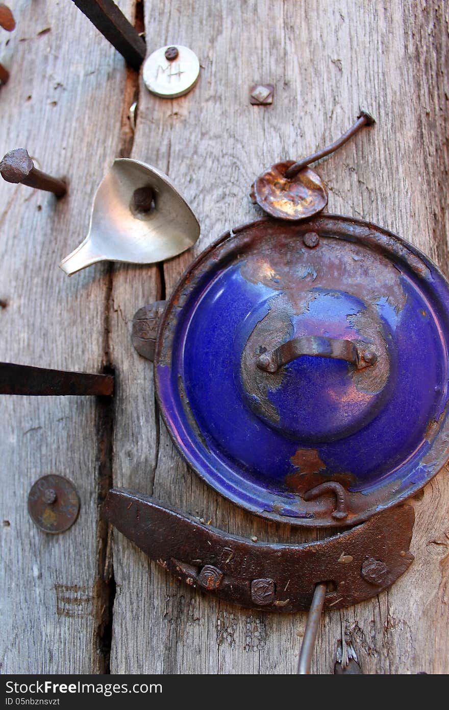 Iron objects and cover pot nailed to a piece of old wood. Iron objects and cover pot nailed to a piece of old wood