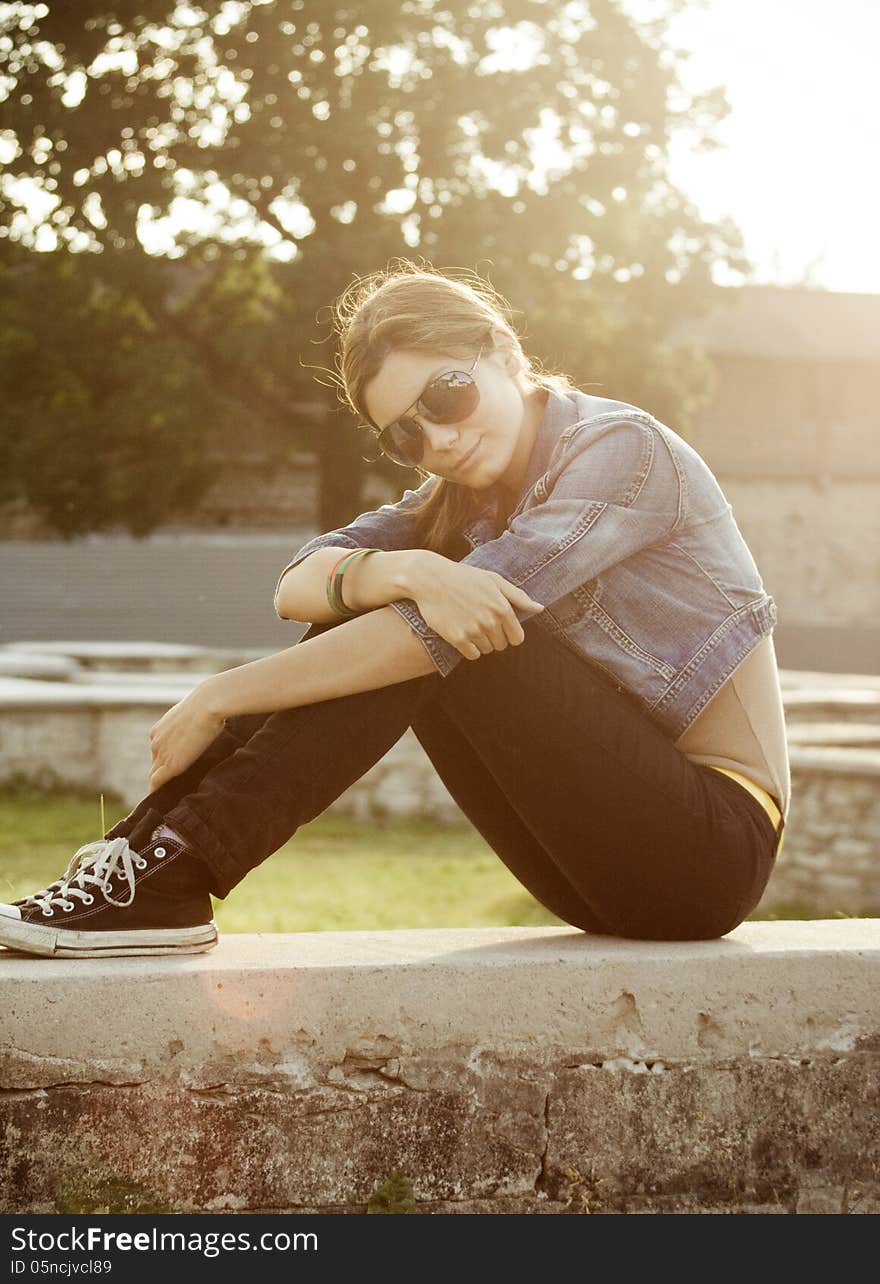 Young beautiful girl in sneakers, vertical, sitting. Young beautiful girl in sneakers, vertical, sitting