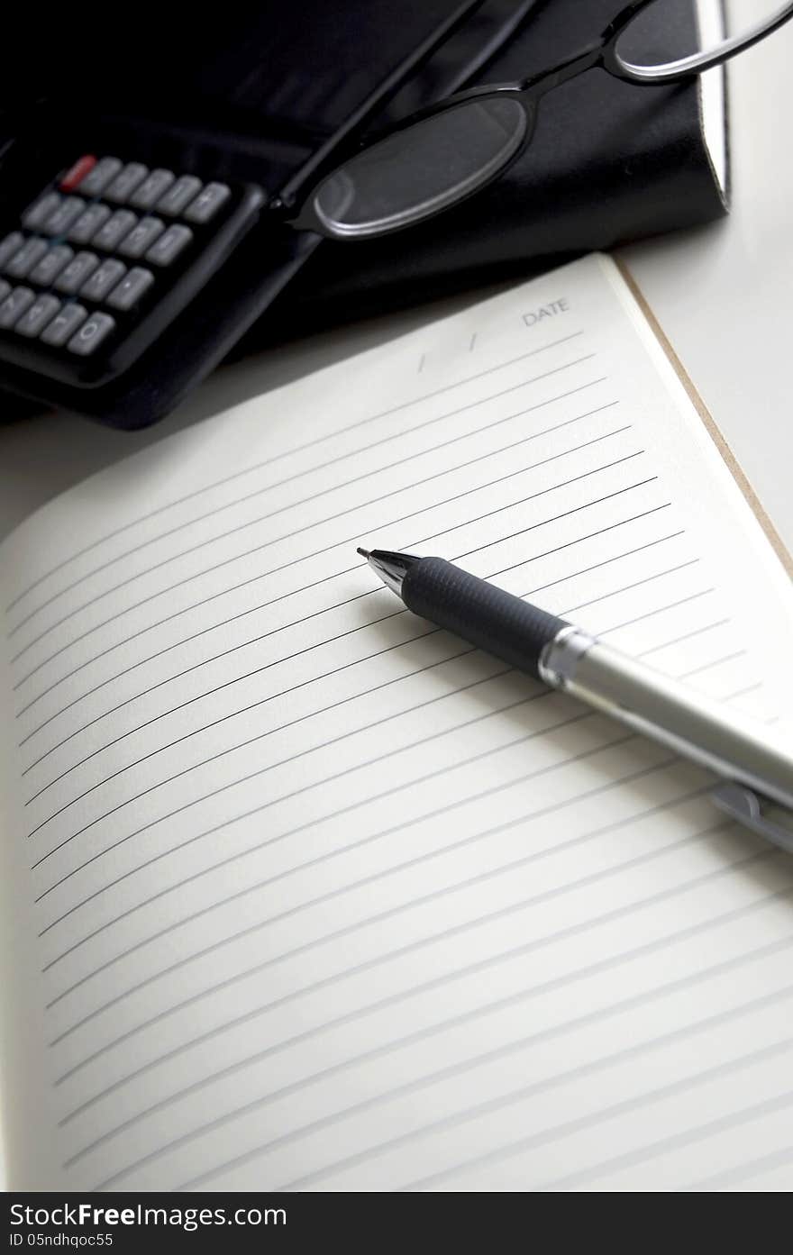 Blank page notebook with pen and calculator on desk. Blank page notebook with pen and calculator on desk