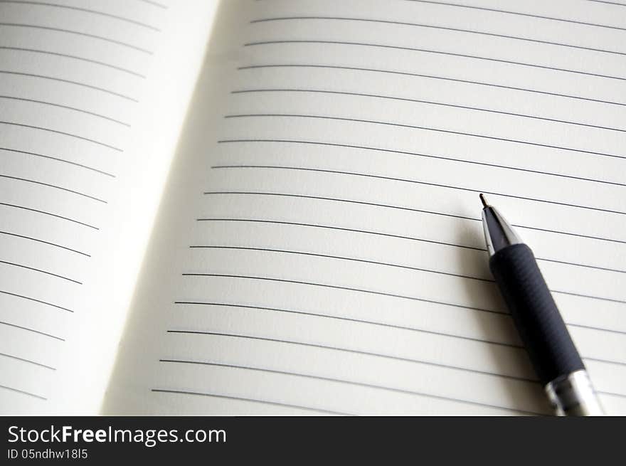 Open blank pages of notebook with pen. Open blank pages of notebook with pen