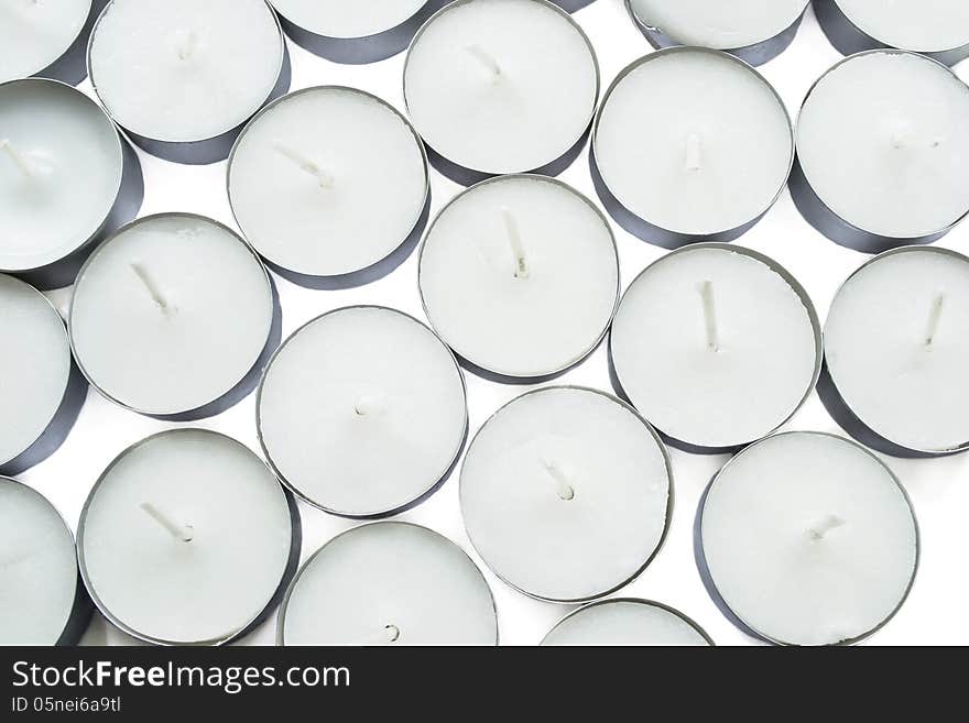 A lot of white tea lights on white background