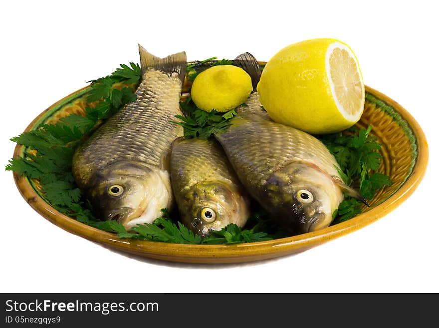 Three carp on ceramic dish , greens and lemon