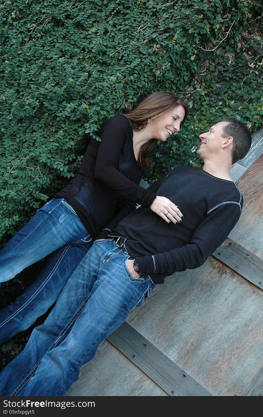 Married couple standing at the top of stairs in front of a vintage wood door looking at each other. Married couple standing at the top of stairs in front of a vintage wood door looking at each other.