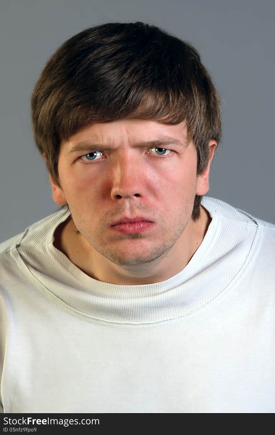 Angry man, face close up, gray background. Angry man, face close up, gray background