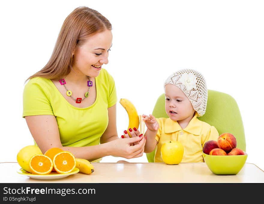 Mother feeding little girl with healthy food sitting at table isolated on white