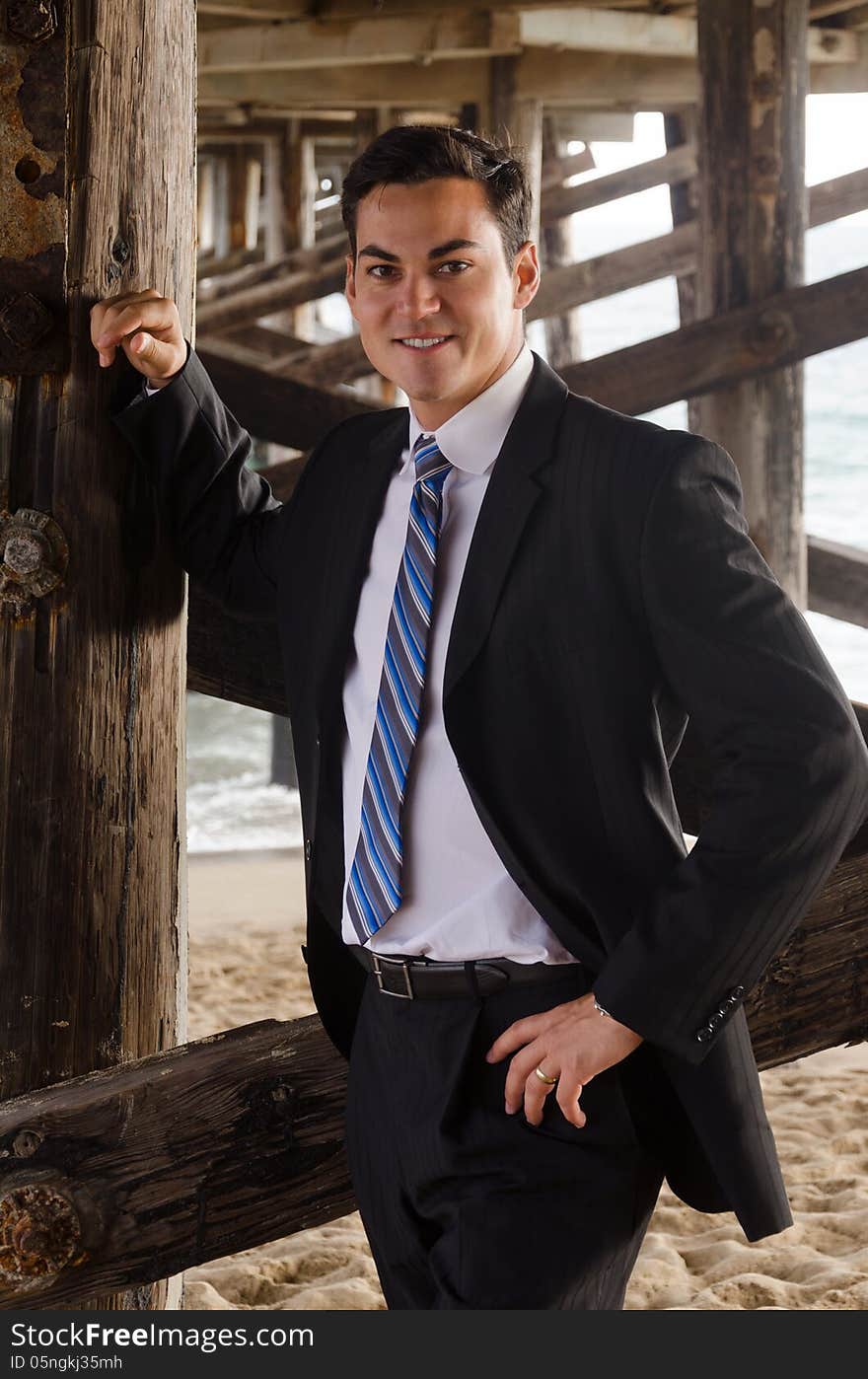 Good looking young man at the beach under the pier. Good looking young man at the beach under the pier.