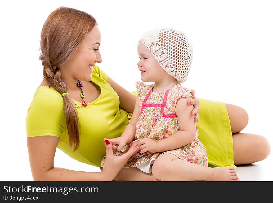 Happy mother and little girl lying on white floor and smiling