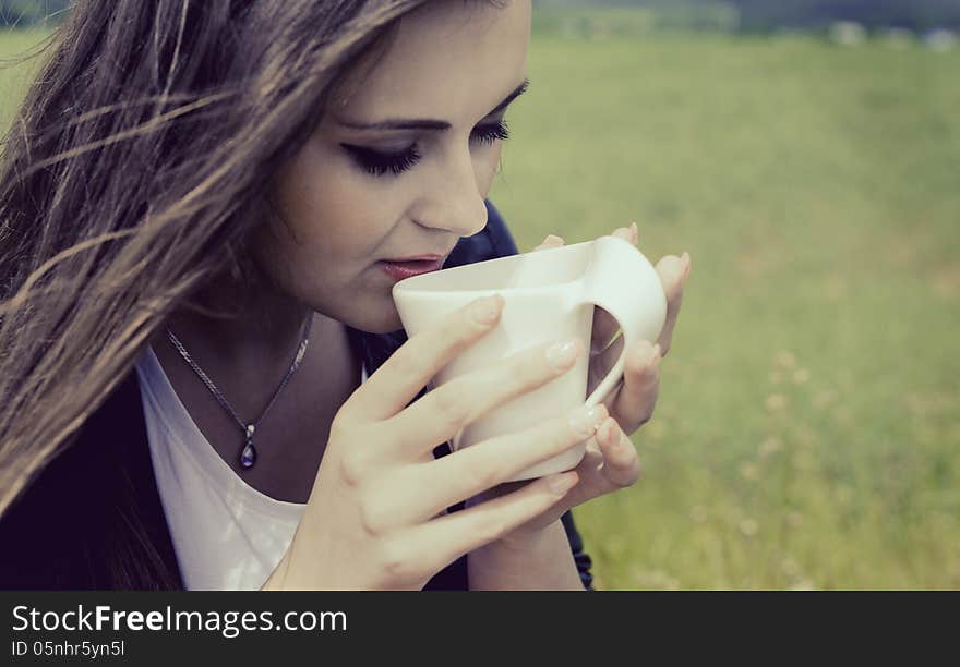 Girl Drinks Coffee With Pleasure Outdoors