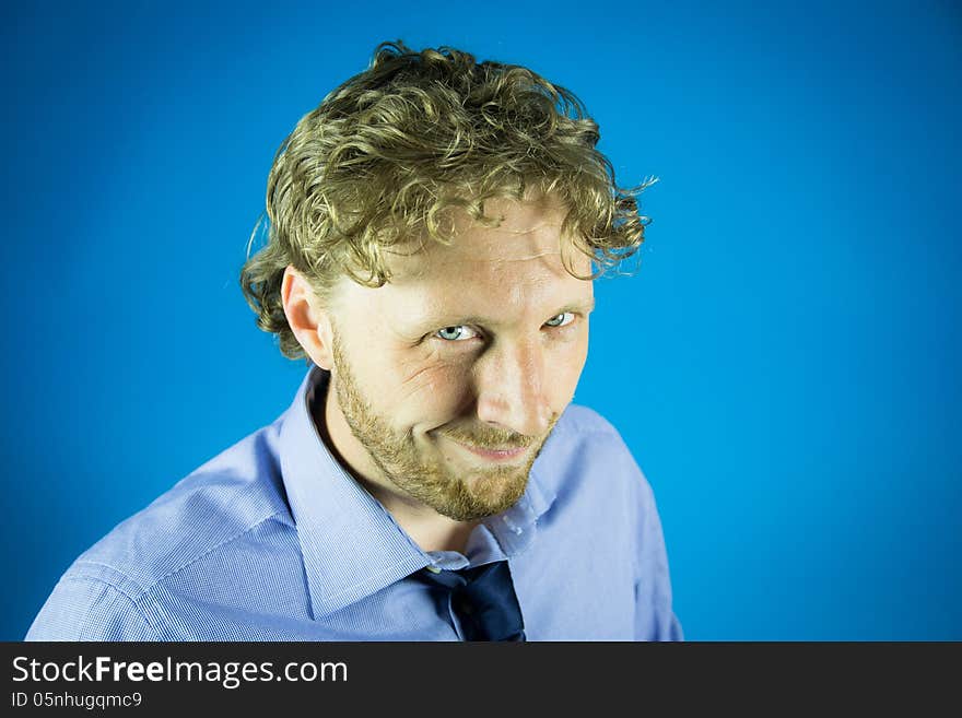 Knowing look of a business man with tie on blue background