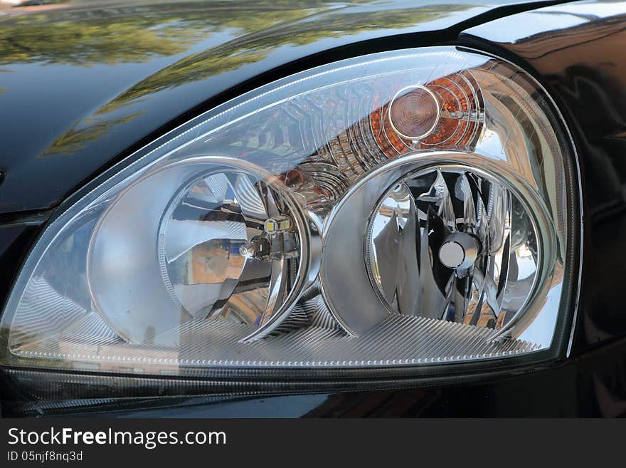 Elegant Headlights new black modern car with a powerful, bright light. Elegant Headlights new black modern car with a powerful, bright light.