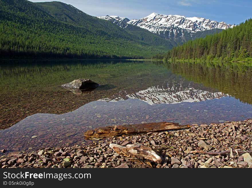 This image of the snowy mountain in the background and reflected in the water was taken at Stanton Lake in the Great Bear Wilderness of NW Montana. This image of the snowy mountain in the background and reflected in the water was taken at Stanton Lake in the Great Bear Wilderness of NW Montana.