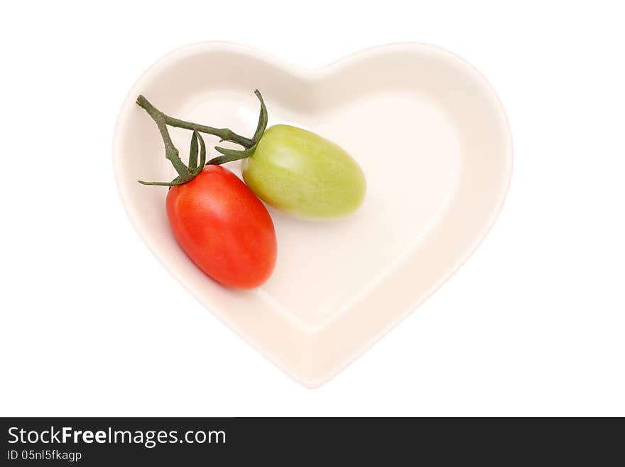 Branch of the two cherry tomatoes on heart-shaped plate