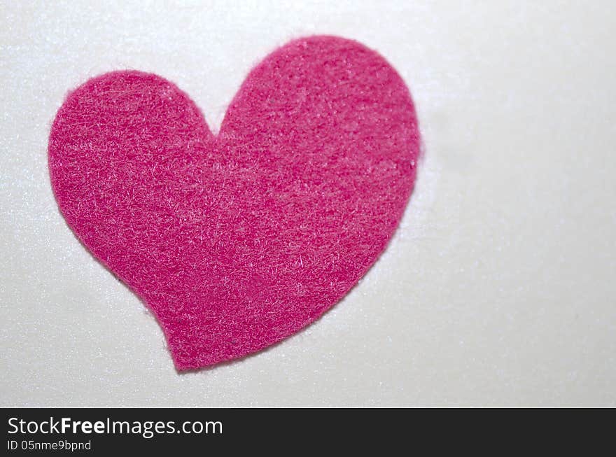 A heart shaped felt texture glued on a white sheet of paper. A heart shaped felt texture glued on a white sheet of paper