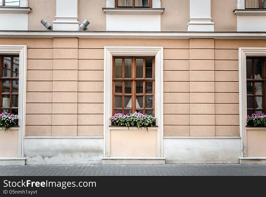 Brown wooden windows decorated with pink flowers. Brown wooden windows decorated with pink flowers