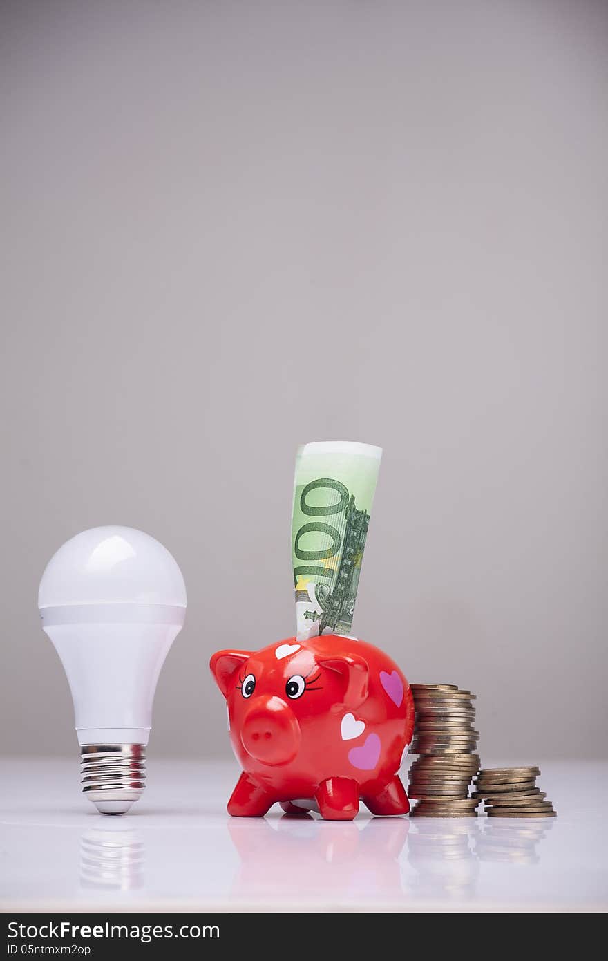 Piggy bank and savings going from the use of LED light bulbs. Piggy bank and savings going from the use of LED light bulbs