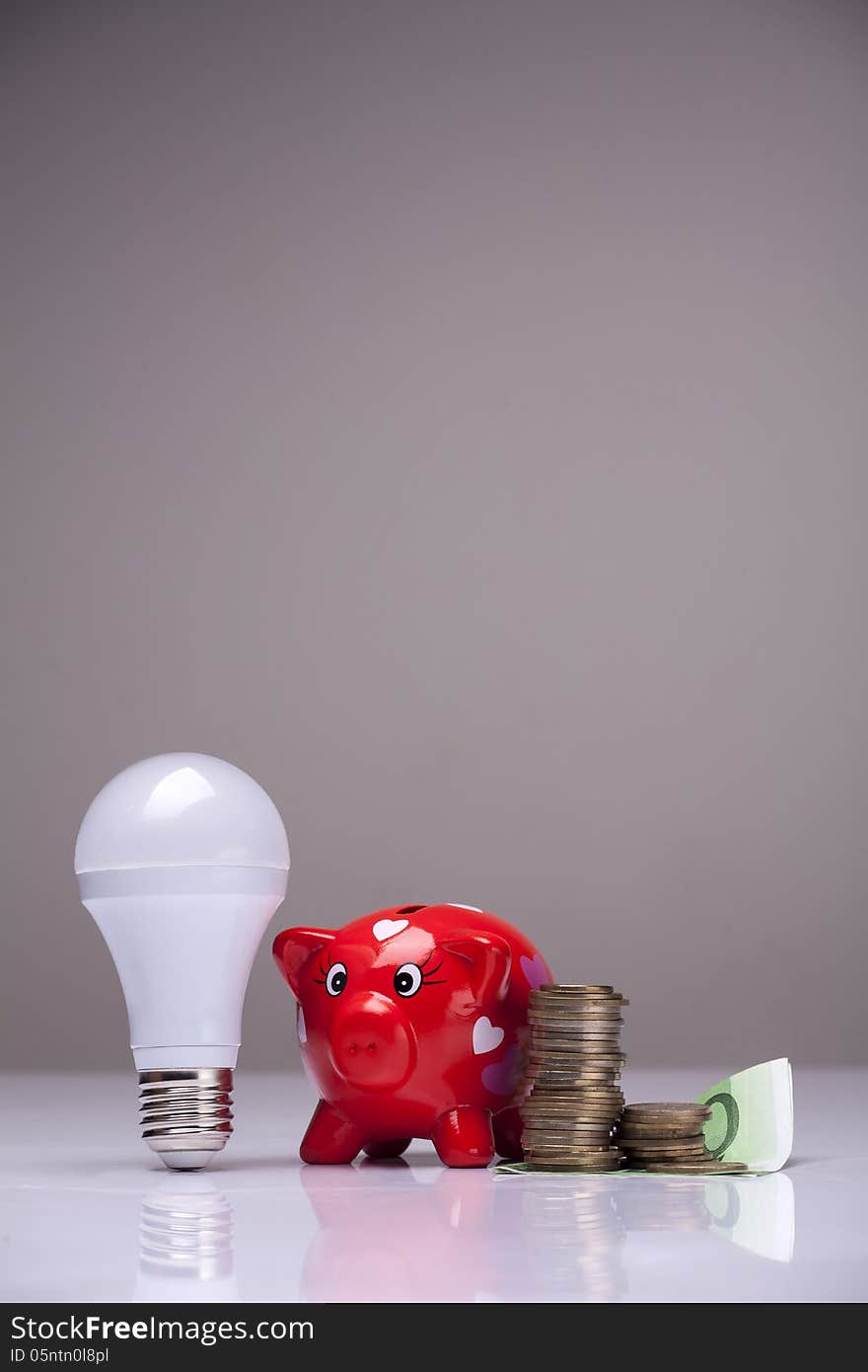 Piggy bank and savings going from the use of LED light bulbs. Piggy bank and savings going from the use of LED light bulbs