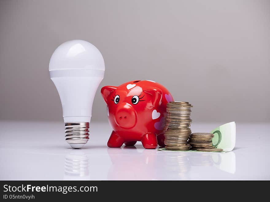 Piggy bank and savings going from the use of LED light bulbs. Piggy bank and savings going from the use of LED light bulbs