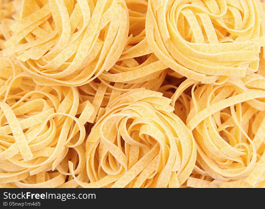 Yellow pasta fettuccine on a whole background. Yellow pasta fettuccine on a whole background