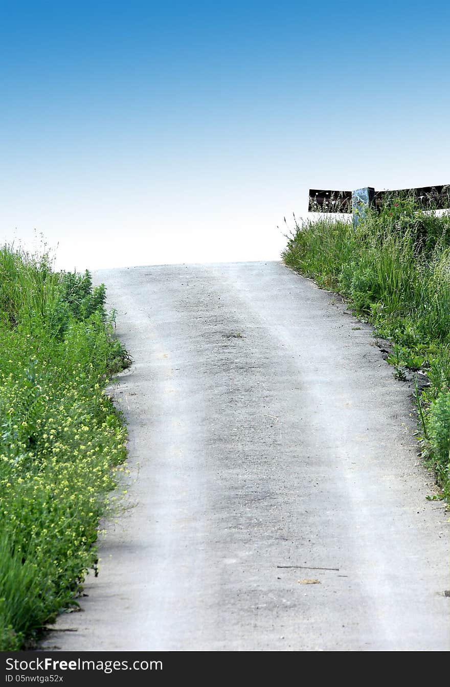 Road on the heaven. Dirt road. Green grass. Blue sky.