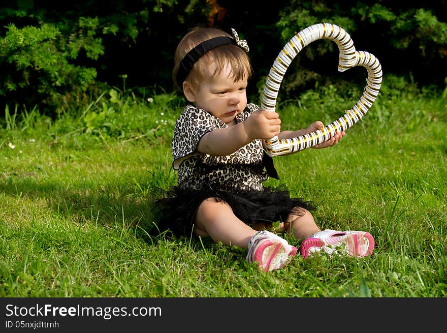 Little child holding a heart on nature