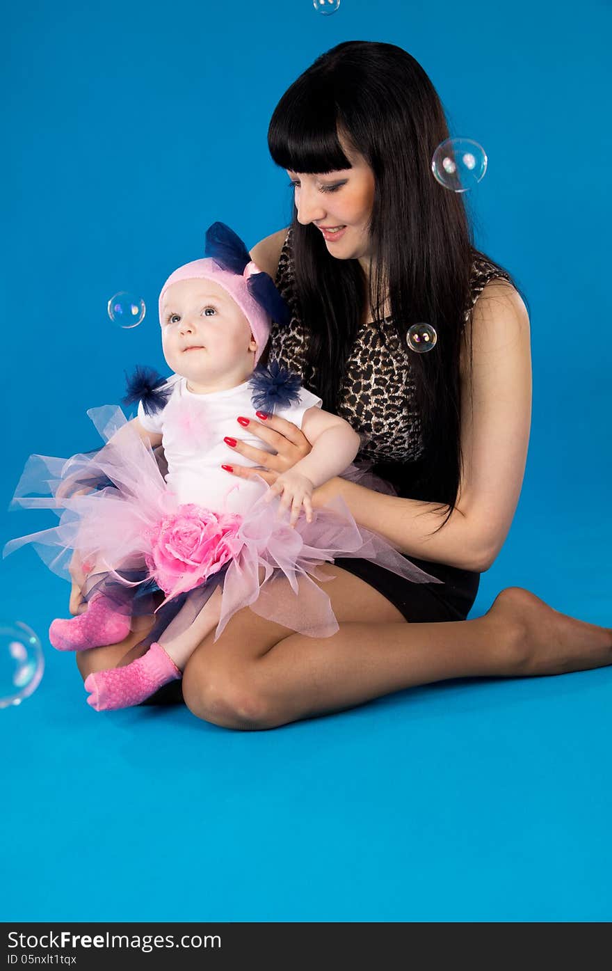 Happy mother with a baby on a blue background. Happy mother with a baby on a blue background