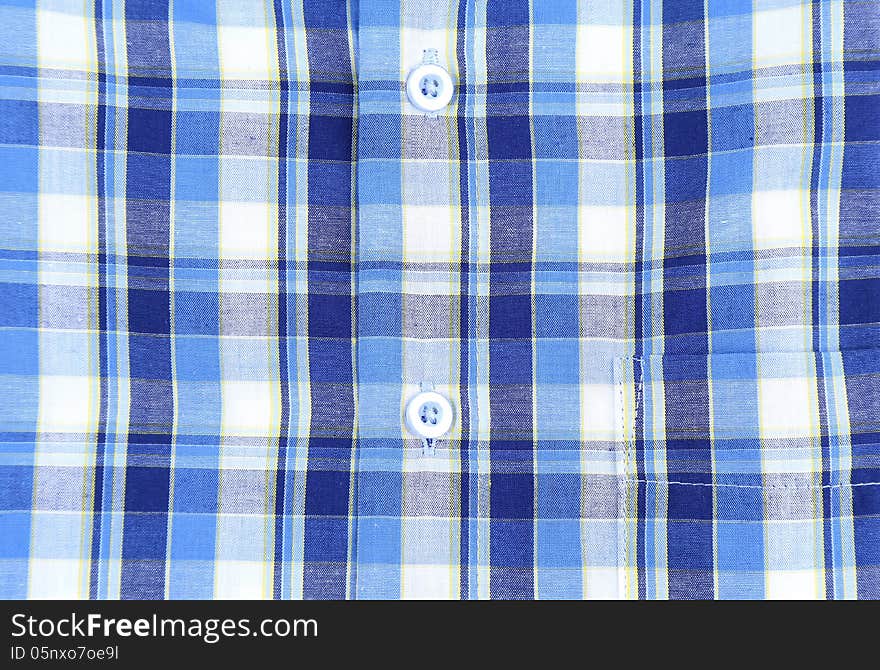 Plaid man shirt, button close-up on a whole background. Plaid man shirt, button close-up on a whole background