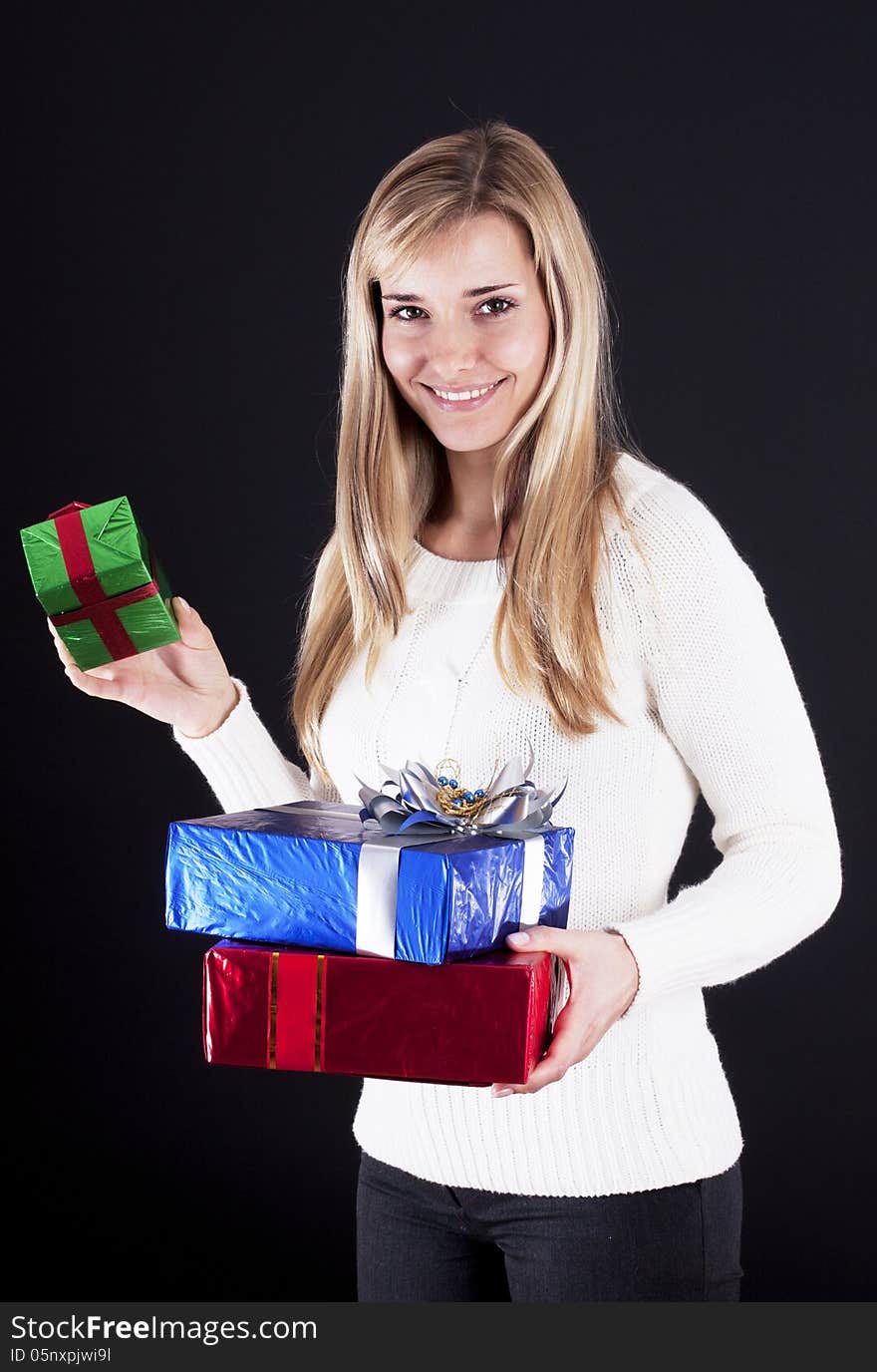 Attractive young woman with gift boxes, isolated on black. Attractive young woman with gift boxes, isolated on black.