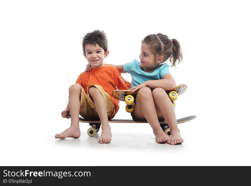 Photography of preschool boy and girl are sitting on a big skate board in a studio on white background. Photography of preschool boy and girl are sitting on a big skate board in a studio on white background