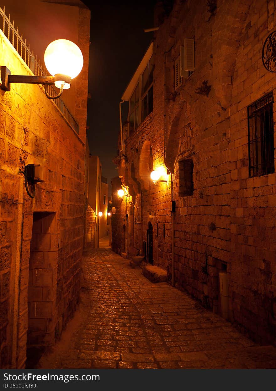 Narrow stone paved medieval street at night in old Jaffa Israel